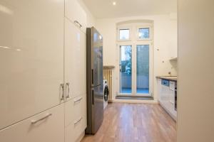 a kitchen with white cabinets and a large window at RAJ Living - 1 or 3 Room Apartments - 20 Min Messe DUS and Old Town DUS in Düsseldorf
