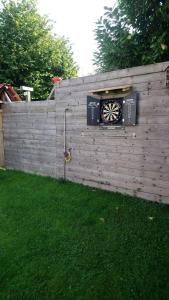 een houten hek met een dartbord aan een muur bij Superb vacancy at Patricks house 