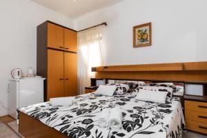 a bedroom with a bed with a black and white comforter at Guest House Cesic in Dubrovnik