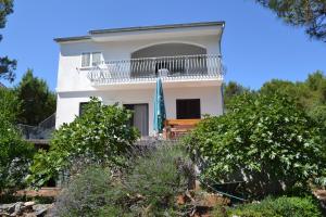 a white house with a balcony and trees at Apartment Hvar Bike in Stari Grad