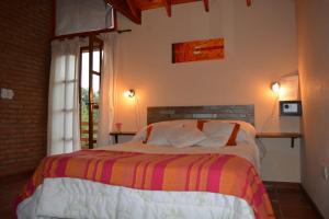 a bedroom with a bed in a room with a window at Cabañas La Belen in Merlo