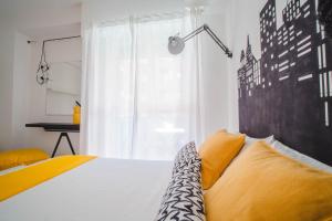 um quarto com uma cama com almofadas amarelas e uma janela em Lady Butterfly - Metro A Lucio Sestio em Roma