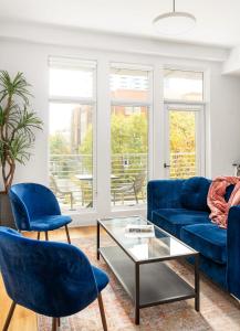 a living room with a blue couch and chairs at Marvelous Midtown Manor In Piedmont Park in Atlanta