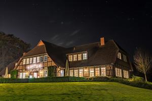 uma casa grande à noite com as luzes acesas em Landhaus am Golfpark em Langenhagen