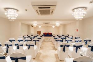 Pokój z białymi krzesłami i niebieskimi łukami w obiekcie Neelams The Grand Hotel w mieście Calangute