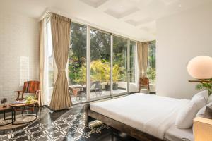 um quarto com uma cama e uma grande janela em La Zamora Estate em Assagao
