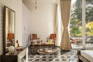 La Zamora Estate في Assagao: غرفة معيشة مع طاولة وكراسي ونافذة كبيرة