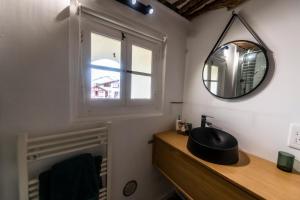 a bathroom with a mirror and a sink and a window at Studio design - Proche plage in Biarritz