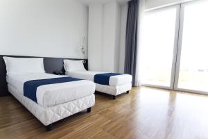 マントヴァにあるHotel Mantova Residenceのベッド2台と大きな窓が備わるホテルルームです。