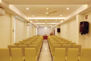 una sala de conferencias vacía con sillas amarillas y techo en Hotel Floral Park en Kottayam