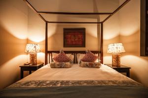 فندق بيناغا في جورج تاون: غرفة نوم مع سرير ومصباحين من الجهتين