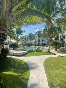 a walkway through a resort with palm trees at Atmospheric apartment with a beautiful view of the swimming pool in Bayahibe
