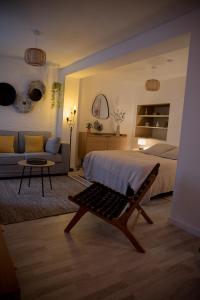 a bedroom with a bed and a couch and a table at Calme et cosy in Obernai