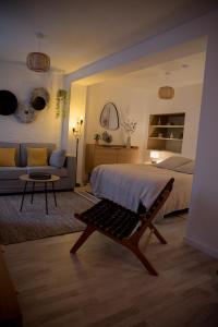 a bedroom with a bed and a couch and a table at Calme et cosy in Obernai +6 photos