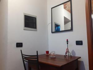 Pokój z drewnianym stołem i lustrem na ścianie w obiekcie Cà Tinola w mieście Mango