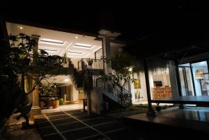 a house with a bench in a courtyard at night at Umah Dayuh in Uluwatu
