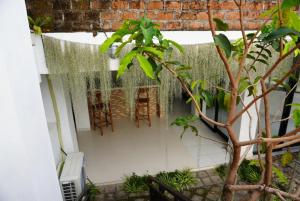 a patio with a table and chairs and a tree at Umah Dayuh in Uluwatu
