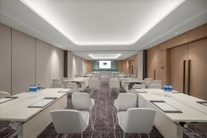 a conference room with white tables and white chairs at Holiday Inn Express Nantong North Gateway, an IHG Hotel in Nantong