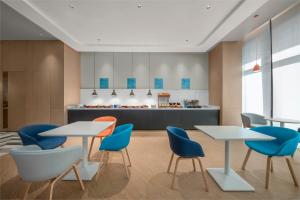 a cafeteria with tables and chairs and a counter at Holiday Inn Express Nantong North Gateway, an IHG Hotel in Nantong