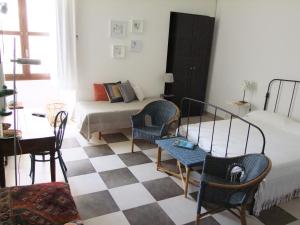 a bedroom with a bed and chairs and a checkerboard floor at A' naca in Ragusa
