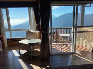 a room with a chair and a balcony with a view at Top Cloud Villa in Renai