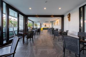 - une salle à manger avec des tables, des chaises et des fenêtres dans l'établissement Lani Chiang Mai Hotel, à Chiang Mai