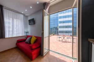 ein Wohnzimmer mit einer roten Couch und einer Glasschiebetür in der Unterkunft Masaniello Apartment in Neapel