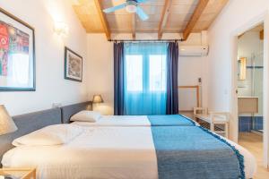 two beds in a room with a window at S'EMBAT in Colonia de Sant Pere +32 photos