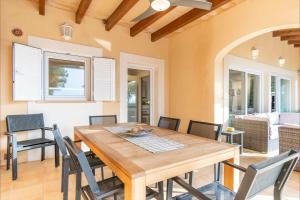 a dining room with a wooden table and chairs at S'EMBAT in Colonia de Sant Pere