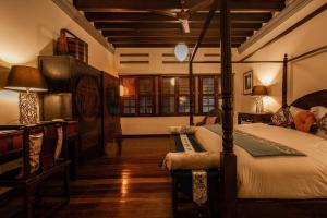 una camera da letto con un letto e un tavolo con una lampada di Hotel Penaga a George Town