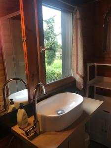 uma casa de banho com um lavatório e uma janela em Chalet à la campagne em Clais
