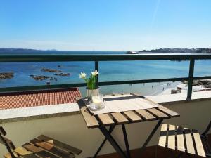 stół na balkonie z widokiem na plażę w obiekcie Precioso ático con vistas a pie de playa w mieście Sanxenxo