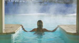 a woman in the water in front of a fountain at Appartement vue exceptionnelle, parking privatif, piscine in Les Orres