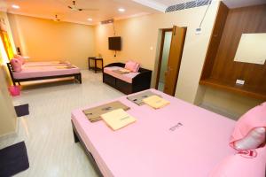 Habitación hospitalaria con 2 camas y mesa en RAMANA'S HOME STAY Apartment Hotel Kumbakonam, en Thanjāvūr