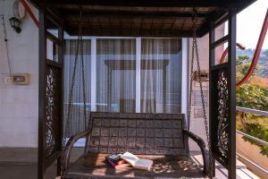 - un banc sur une terrasse couverte avec des livres dans l'établissement StayVista's Princess - A Villa with Infinity Pool & Breathtaking Views, à Lonavala