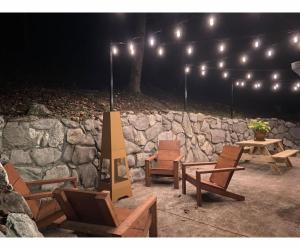 um grupo de cadeiras e uma parede de pedra com luzes em Beary Relaxing Cabin - Rustic with Outdoor Patio em Townsend