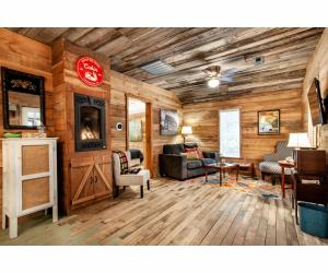 uma sala de estar com paredes de madeira e um sofá e cadeiras em Beary Relaxing Cabin - Rustic with Outdoor Patio em Townsend