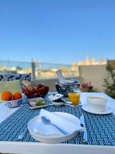 une table avec des assiettes et des bols de nourriture dans l'établissement Nelli's B&B, à Cospicua