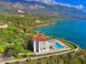 an aerial view of a house next to a body of water at Seafront Villa Kefaloniaprivatevillas in Trapezaki