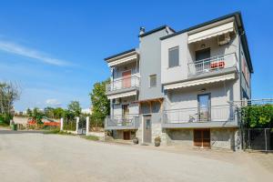a white building with balconies on the side of a street at Kentrikon Rooms III & Mint House in Limenaria