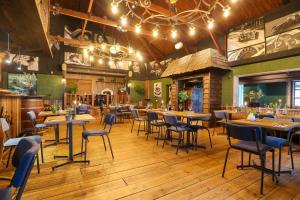 a restaurant with wooden floors and tables and chairs at EuroParcs Beekbergen in Beekbergen +20 photos