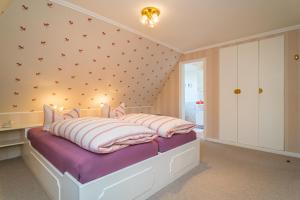 sypialnia z łóżkiem z białymi i różowymi poduszkami w obiekcie Schallers Hüs 2 w mieście Tinnum