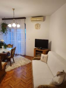 a living room with a white couch and a television at Apartman Noa in Knin