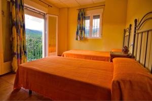 2 camas en una habitación con ventana grande en Alojamiento Rural Sierra de Jerez, en Jerez del Marquesado
