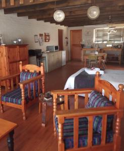 a room with a bed and chairs and a kitchen at PurePlaas Self catering Volmoed Oudtshoorn Klein Karoo in Oudtshoorn