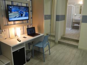 a room with a desk with a laptop and a television at Hotel Moderno in Grumello del Monte