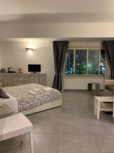 ein Schlafzimmer mit einem Bett und einem TV sowie einige Fenster in der Unterkunft MyB in Neapel