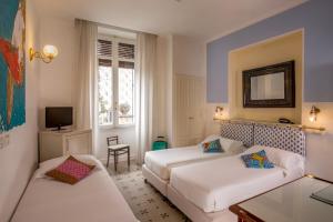 une chambre d'hôtel avec deux lits et un canapé dans l'établissement Hotel Emona Aquaeductus, à Rome