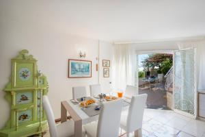een eetkamer met een tafel en stoelen en een klok bij Casa Albatros in Praiano