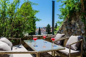 two glasses of wine sitting on a table on a patio at Private Garden Apartment Dubrovnik in Dubrovnik